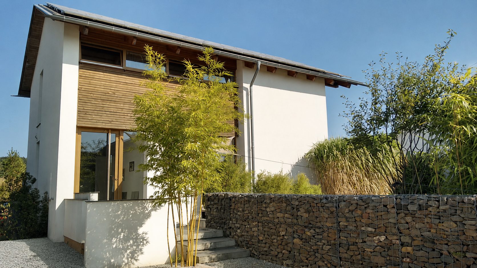 Einfamilienhaus mit Holzfassade und Gartenmauer – Architektur Neurohr